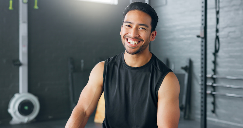 A man smiling in a gym for a workout